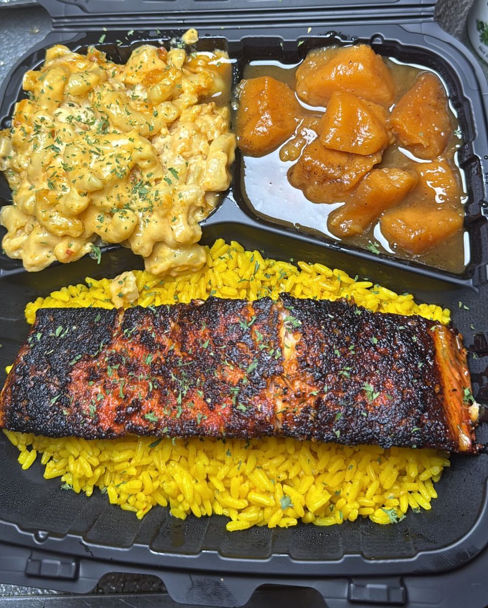 Blackened salmon platter over yellow rice with mac and cheese and candied yams